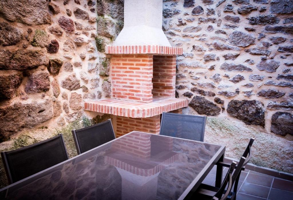 a table and chairs in front of a brick wall at Casa Rural el Meson in Fermoselle