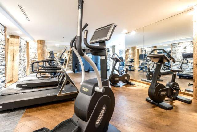 a gym with several treadmills and cardio machines at Hôtel Les Barmes De l'Ours in Val-d'Isère