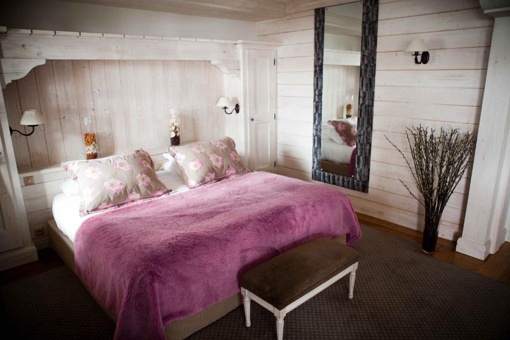 a bedroom with a large bed with a purple blanket at Hôtel Les Barmes De l'Ours in Val-d'Isère