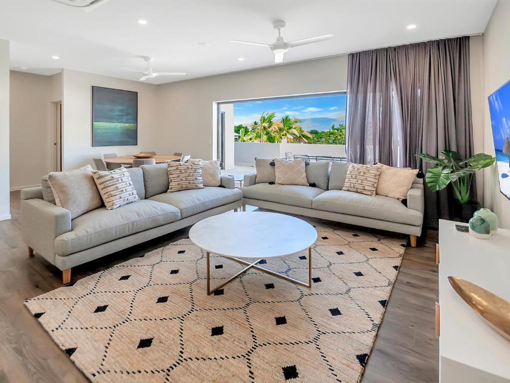 a living room with two couches and a table at Superior Luxury Apartment in the City in Cairns