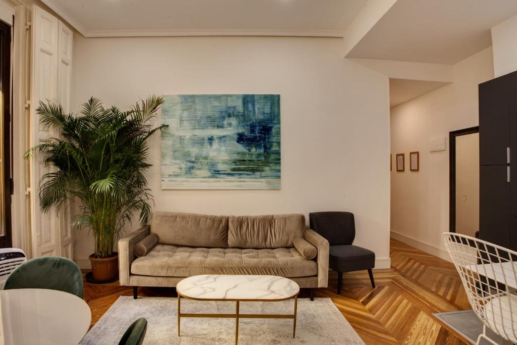 een woonkamer met een bank en een tafel bij SY Fuencarral in Madrid