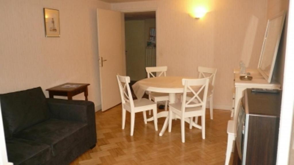 a living room with a table and chairs and a couch at Appartement Centre Ville Tours in Tours