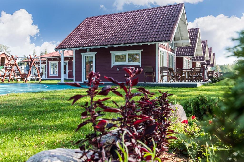 a house with a yard with a playground at Mediniai nameliai Žibų 99 in Šventoji