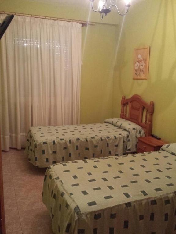 two beds in a room with twothirdsessionsomalybestosbestosbestosbestosbestosbestos at Hostal Vaticano in Alfajarín