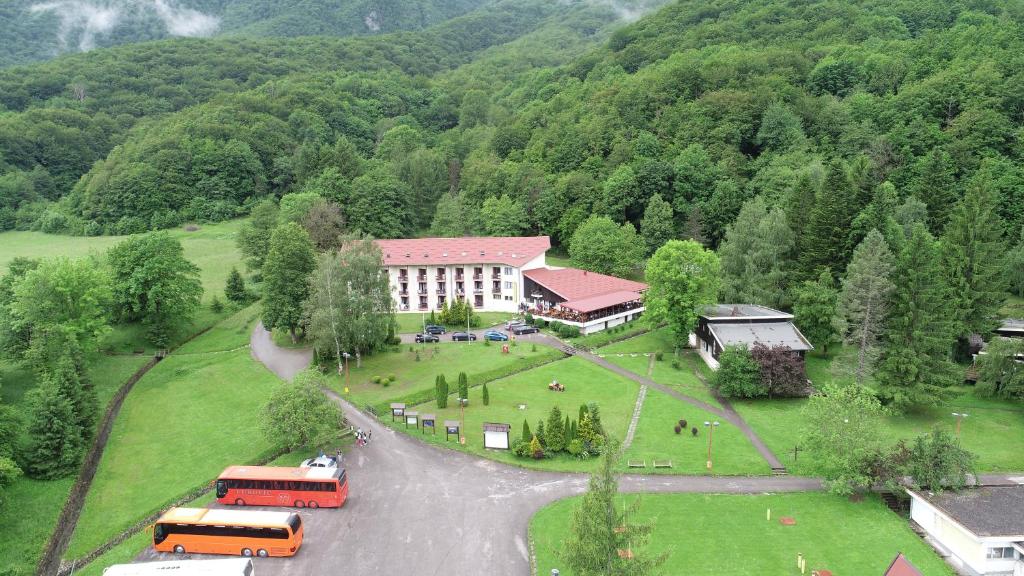 een school met bussen geparkeerd voor een gebouw bij Hotel Mladost in Tjentište