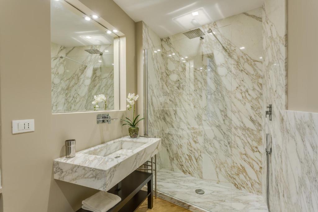 W łazience znajduje się marmurowy prysznic i umywalka. w obiekcie Sophisticated Home we Florencji
