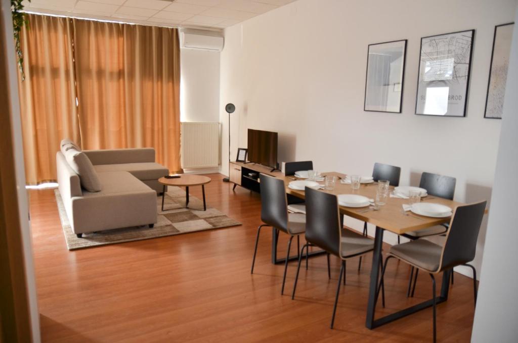 a dining room with a table and chairs and a couch at Studio D&T in Slavonski Brod