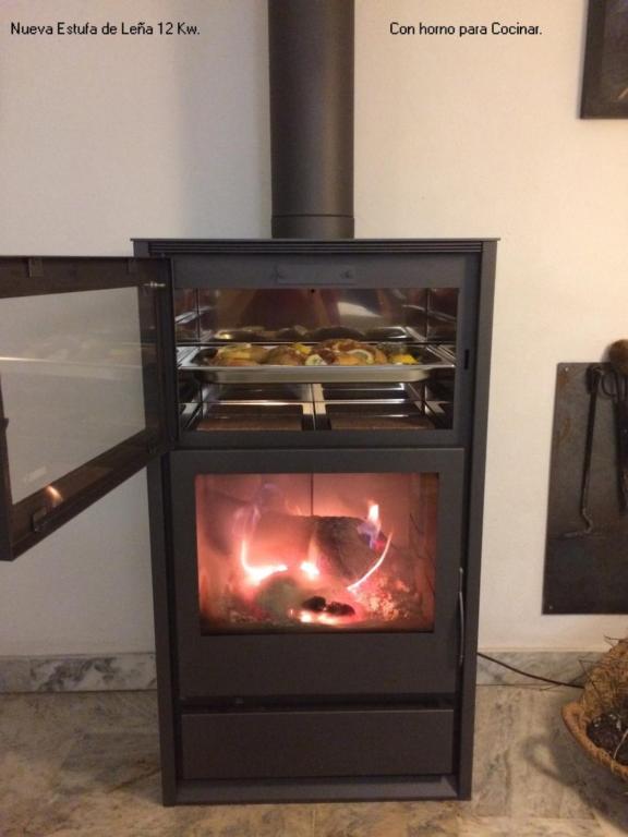 a stove with a oven with food inside of it at Antigua Panadería de Valdelarco, chimenea con horno 2 Hab 4 pers mas 2 max in Valdelarco