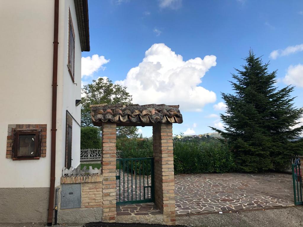 a gate to a house with a tree behind it at CASCINA NELLA CAMPAGNA ABRUZZESE in Isola del Gran Sasso dʼItalia