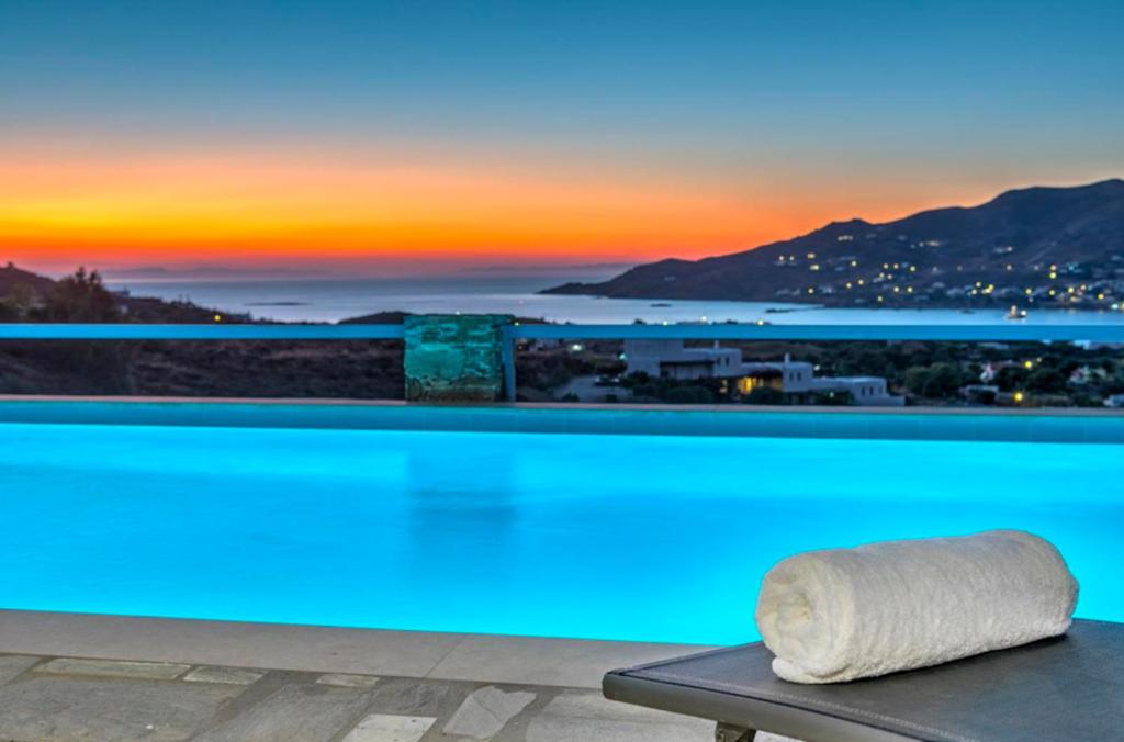 - un matelas installé au-dessus de la piscine avec un coucher de soleil dans l'établissement Oceania House with sea view, à Áno Sýros
