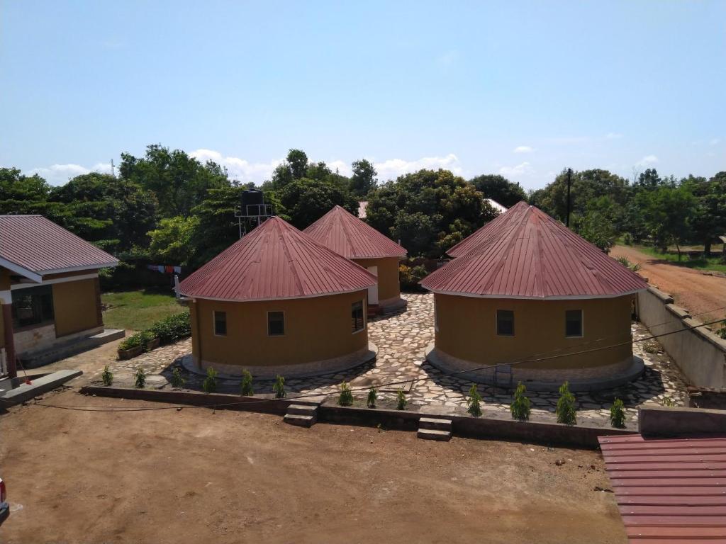 a group of houses with red roofs on a field at Kalalo Cottage Inn in Pakwach East