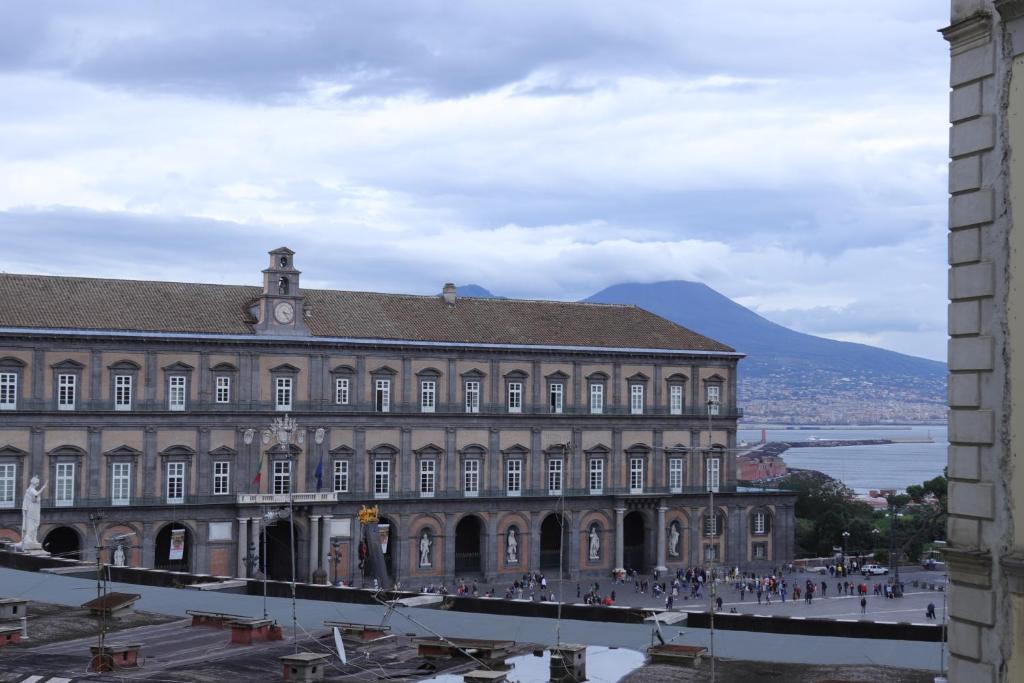 un grande edificio con una montagna sullo sfondo di Mecla Suites a Napoli