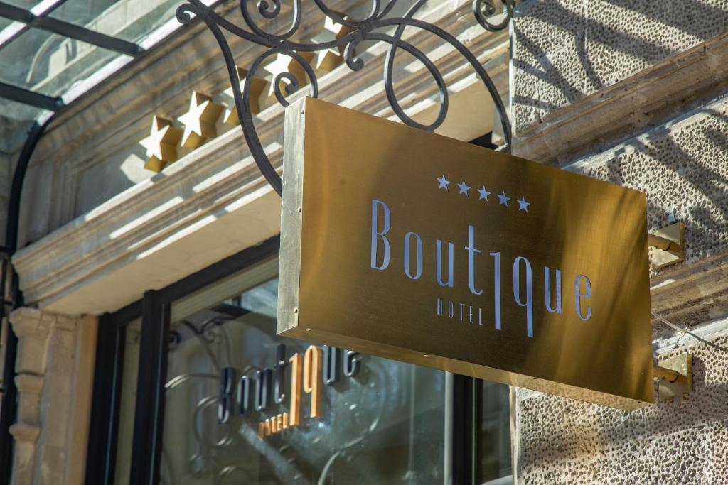 un cartel colgado fuera de la puerta de una tienda en Boutique 19 Hotel, en Baku
