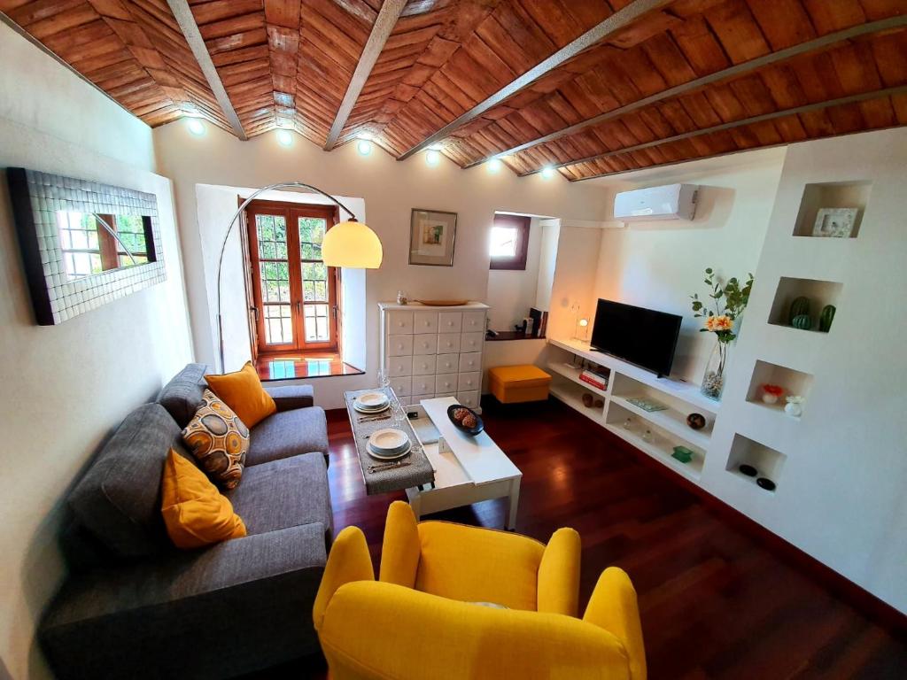 a living room with a couch and a tv at Almocabar Luxury Apartment in Ronda