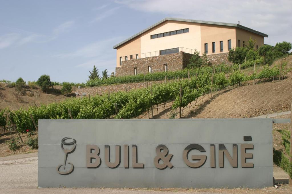 un bâtiment derrière un panneau devant un bâtiment dans l'établissement Buil & Gine Wine Hotel, à Gratallops