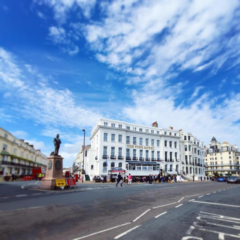 a large white building with a statue in the middle of a street at The Pier Hotel in Eastbourne