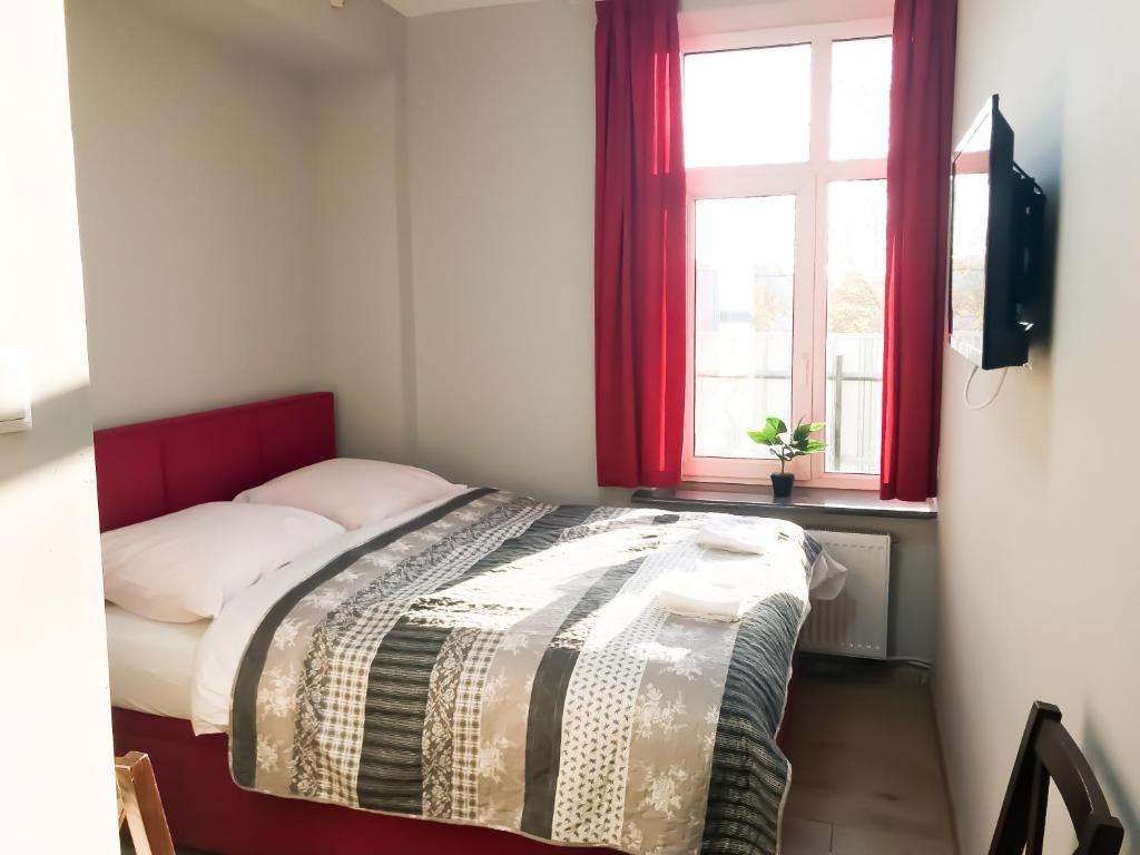 a small bedroom with a bed with a window at Willa Wygoda in Białystok