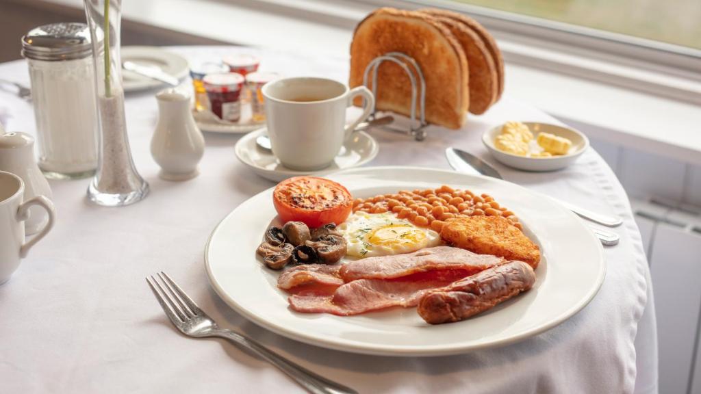 a plate of breakfast food on a table at The Pines Hotel in Swanage