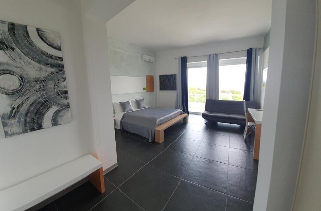 a bedroom with a bed and a couch and a chair at Oasis Park Hotel in Torre dell'Orso