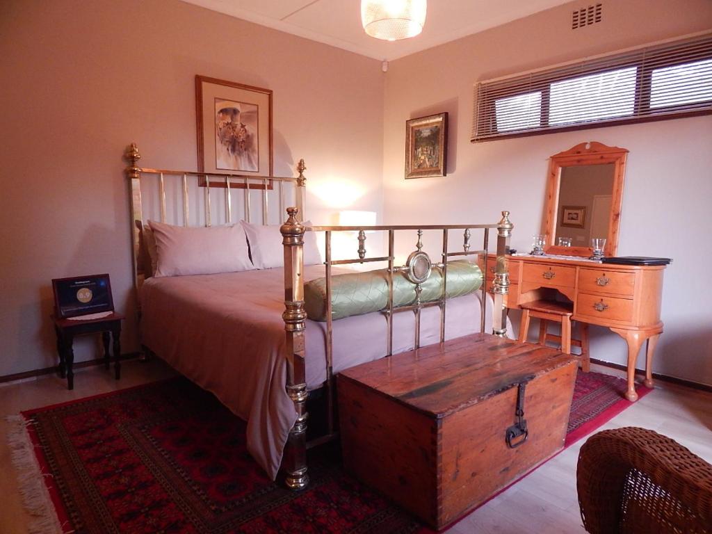 a bedroom with a bed and a wooden dresser and a mirror at Swellendam Overnight Accommodation in Swellendam