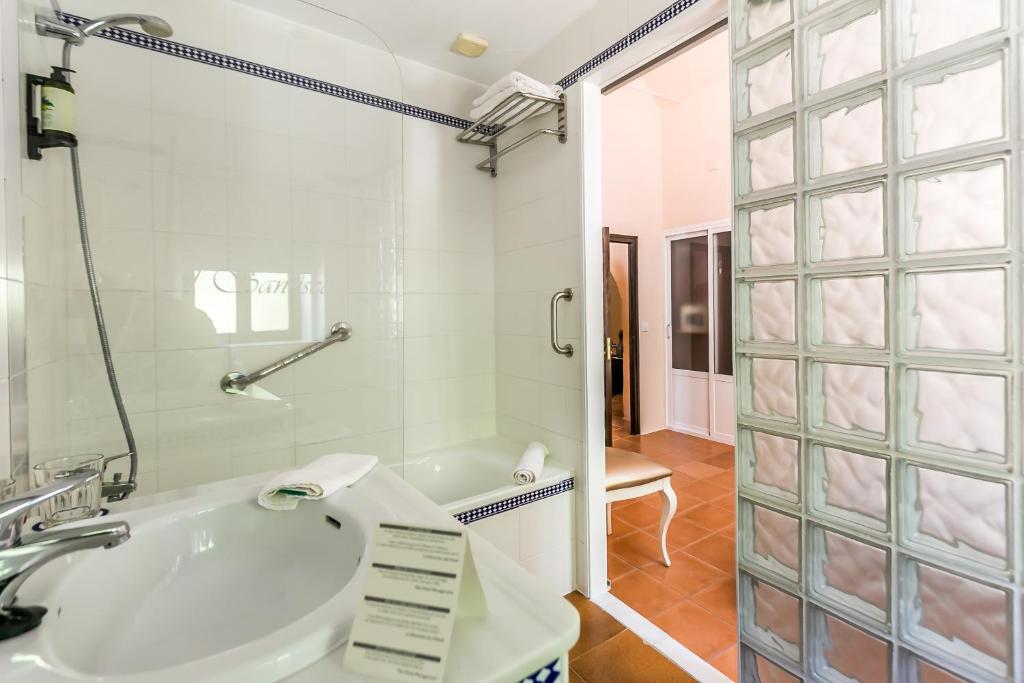 a bathroom with a sink and a glass shower at Hacienda el Santiscal in Arcos de la Frontera