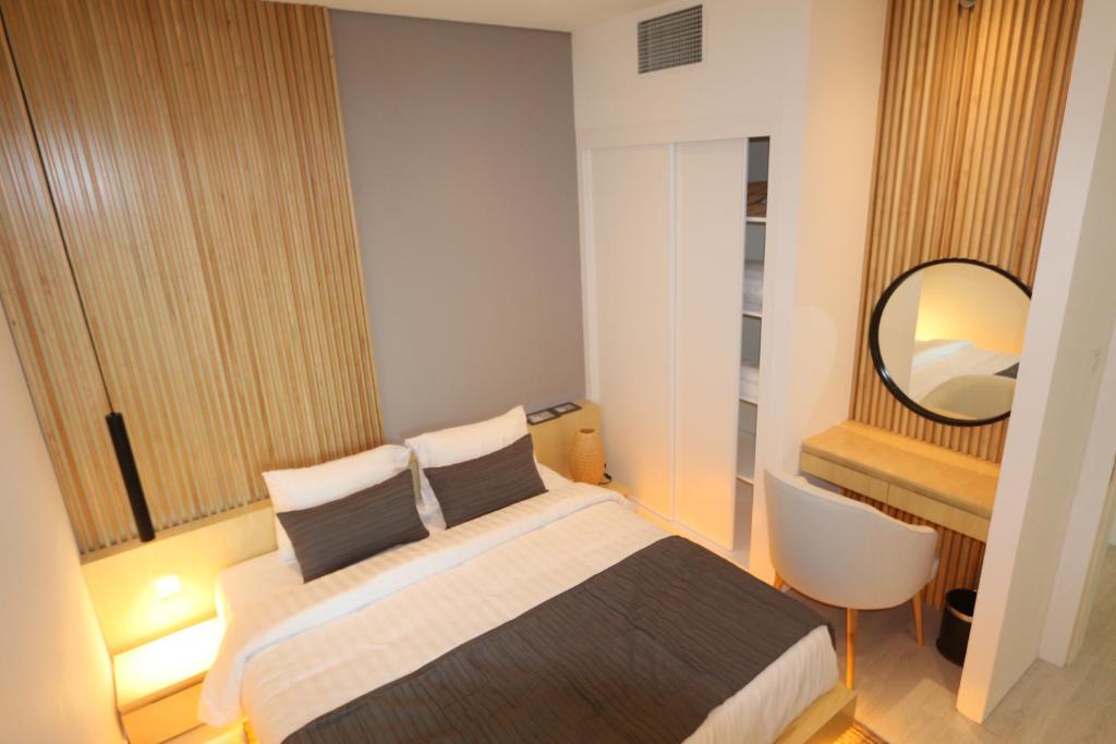 - une petite chambre avec un lit et un miroir dans l'établissement Samaya Holiday Homes, à Dubaï