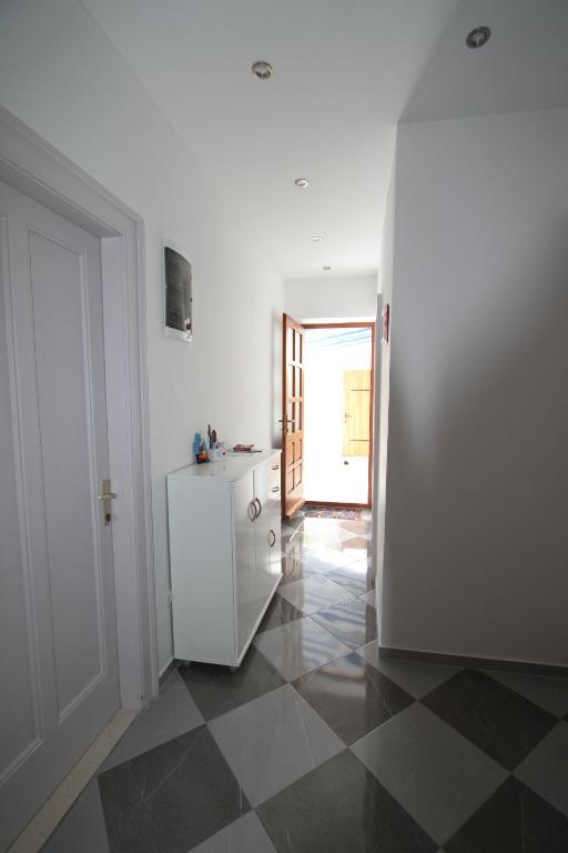a kitchen with a white refrigerator and a tiled floor at Seafront rooms in Hvar