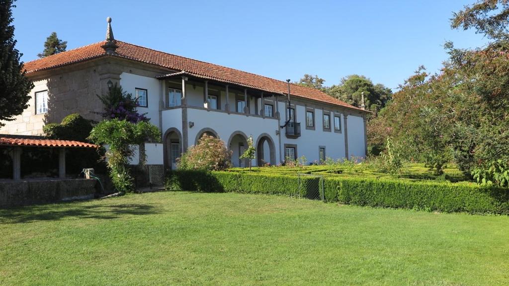 
a large white house with a large window at Quinta De Guimaraes in Miguas
