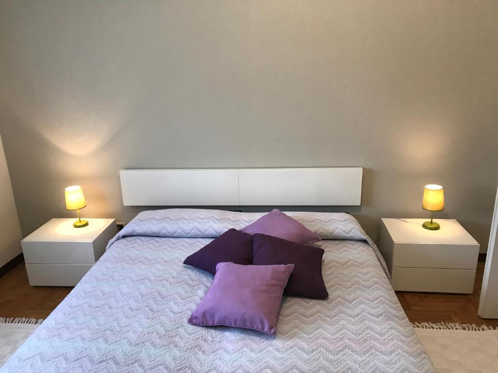 una camera da letto con un grande letto con cuscini viola di Cosy Flat a Treviso