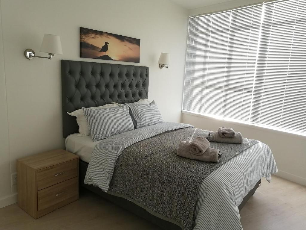 een slaapkamer met een groot bed en handdoeken bij Disa Park 14th Floor Apartment with City Views in Kaapstad