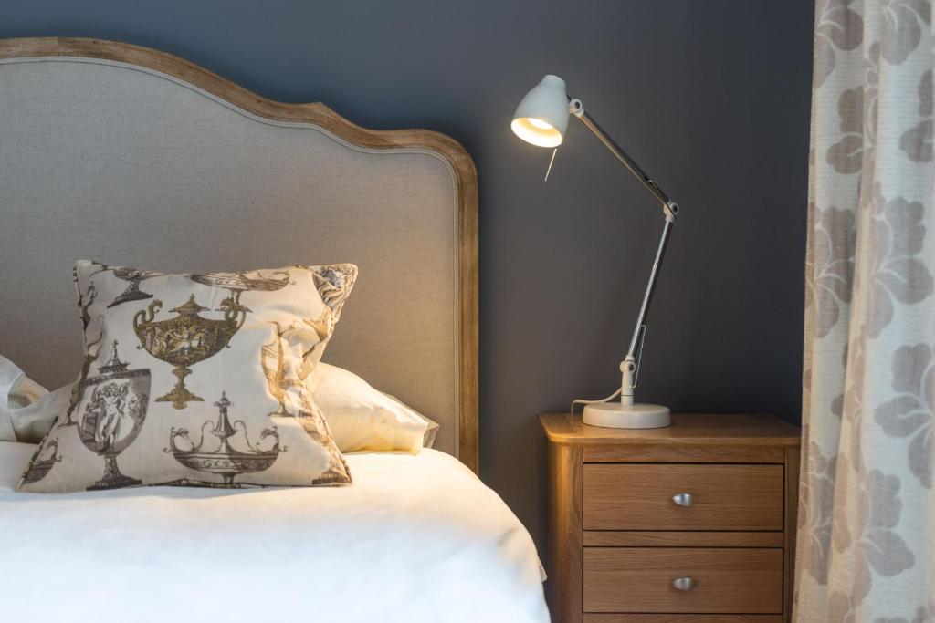 a bed with a pillow and a lamp on a night stand at Kings Stables, Grassmarket in Edinburgh