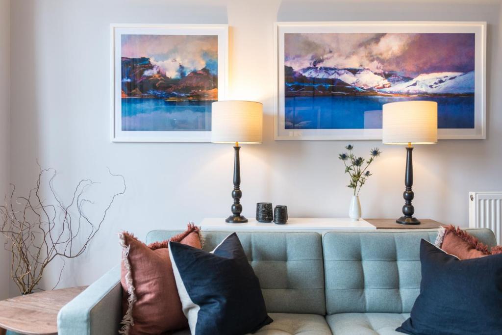 a living room with a blue couch and two lamps at Raeburn Place in Edinburgh