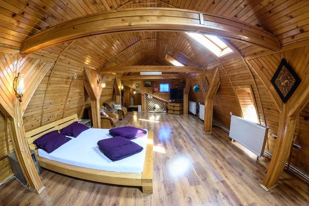 um quarto com uma cama num quarto de madeira em Wooden Attic Suite em Brasov