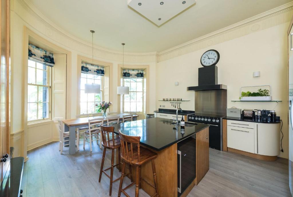 a kitchen with a table and a clock on the wall at Gayfield Place in Edinburgh