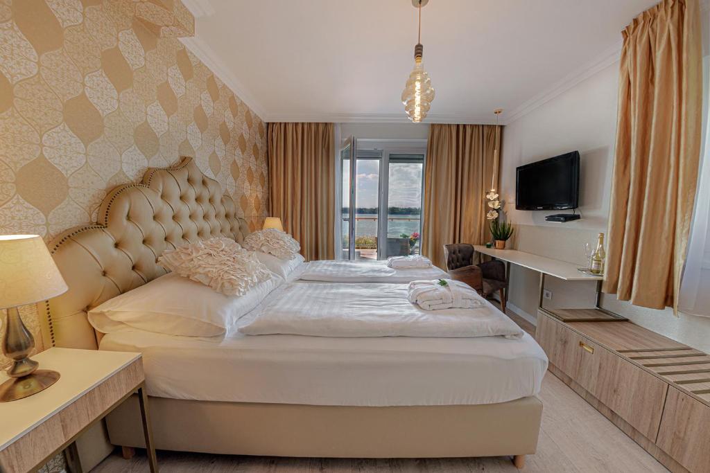 1 dormitorio con 1 cama grande y TV en Casablanca Panzió, en Tata