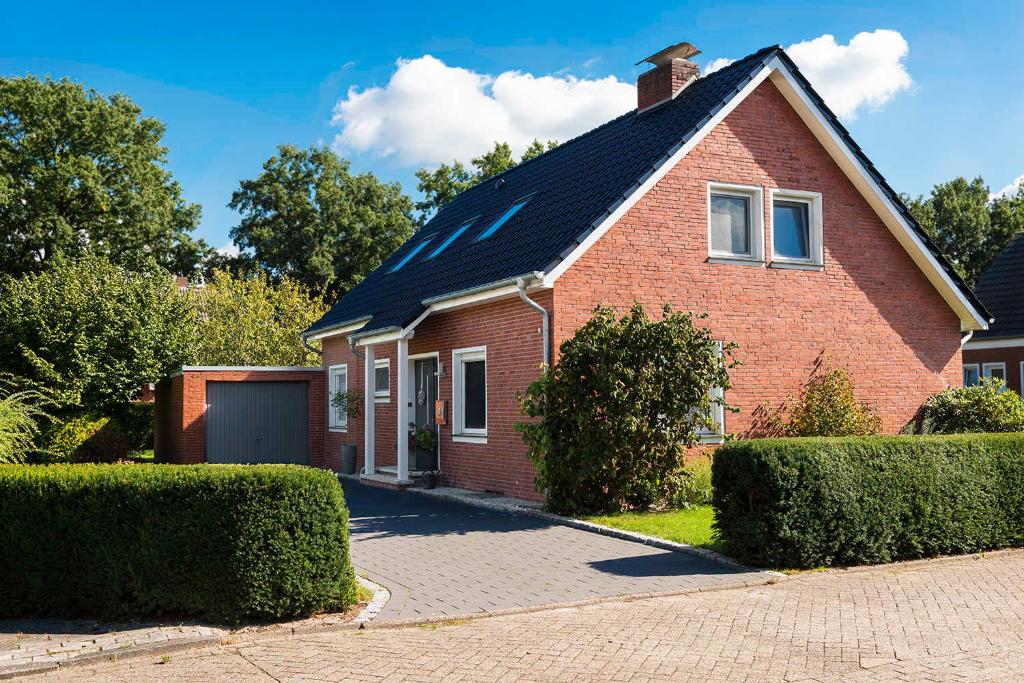 a red brick house with a black roof at Ferienhaus Minnet, 15169 in Leer