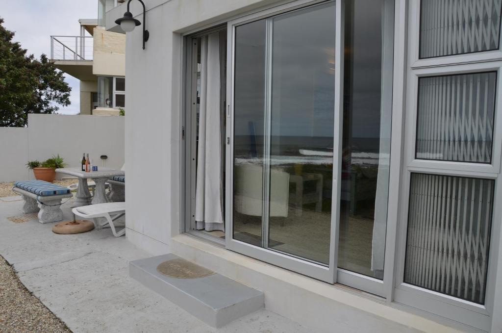 a sliding glass door on the side of a house at Beach Villa Apartment in Hermanus