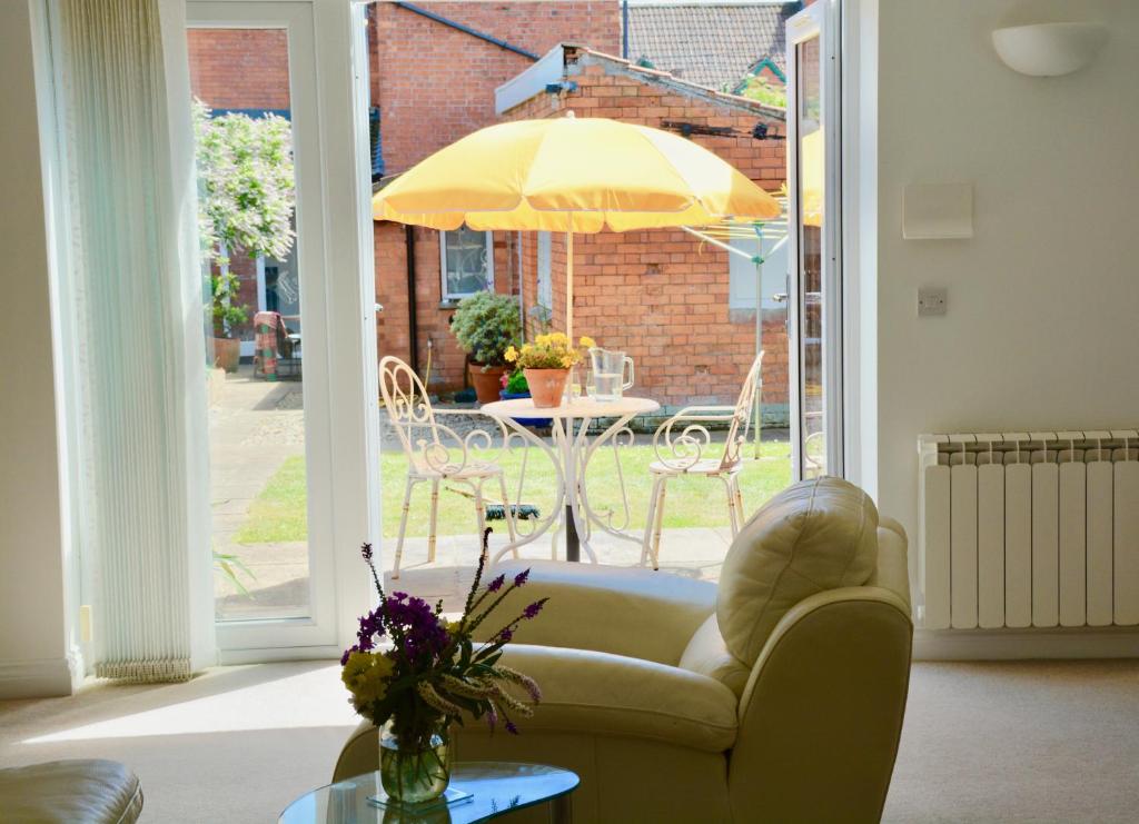 a living room with a couch and an umbrella at glastonbury town garden house in Glastonbury