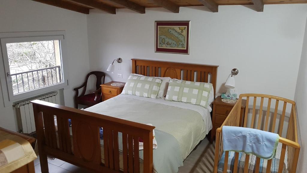 Cherry House B&B في Polinago: غرفة نوم بسرير وسرير أطفال ونافذة