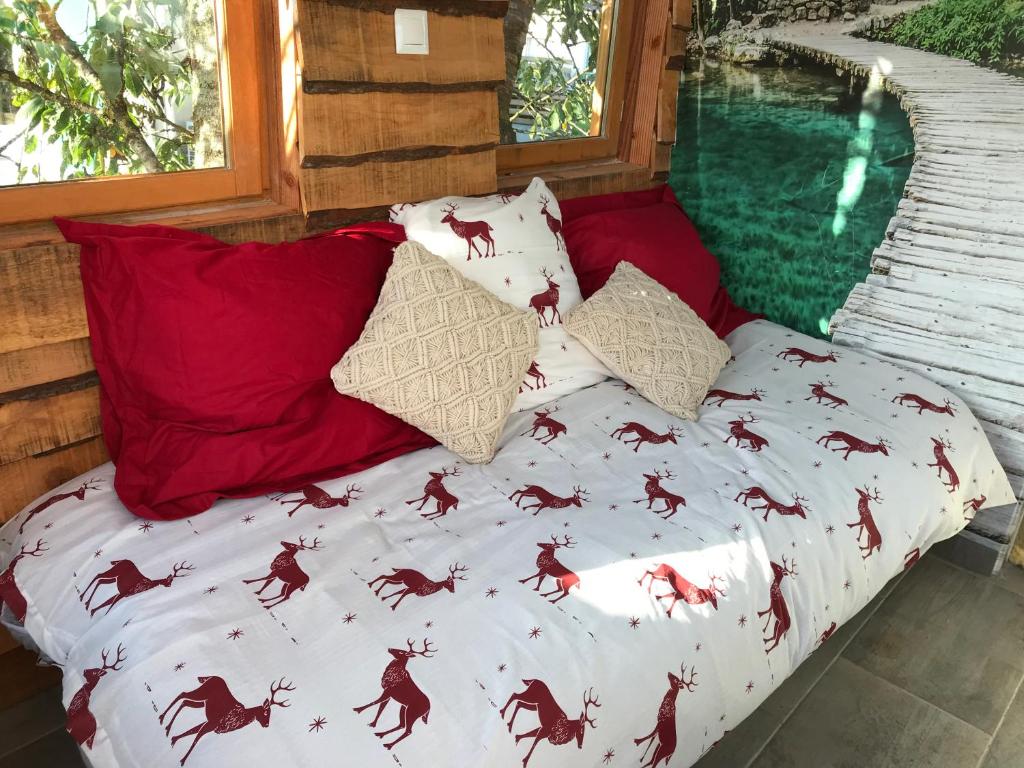 Bett in einem Zimmer neben einem Fenster in der Unterkunft Cabane du hérisson in La Capelle-en-Thiérache