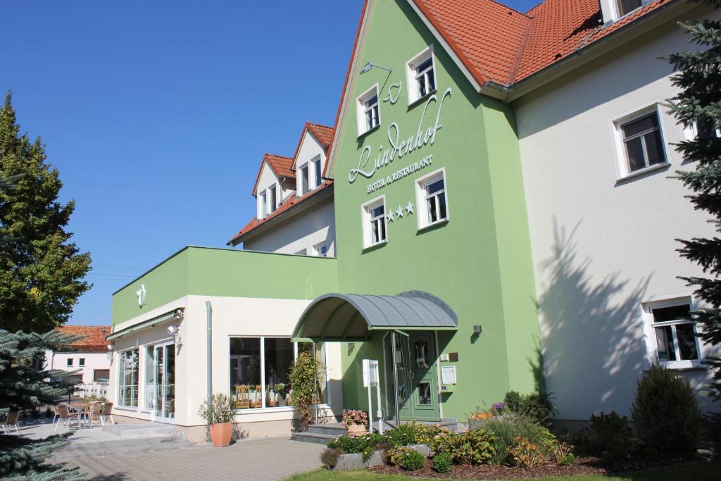 un edificio verde y blanco con una tienda en Lindenhof, en Thiendorf