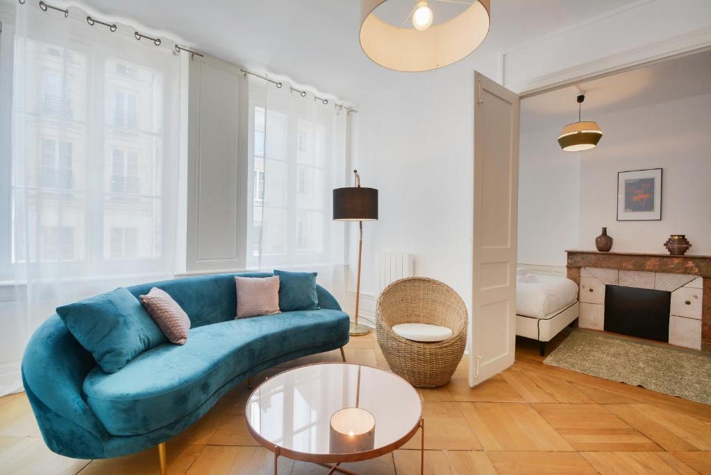 a living room with a blue couch and a fireplace at Le superbe des Dominicains in Nancy