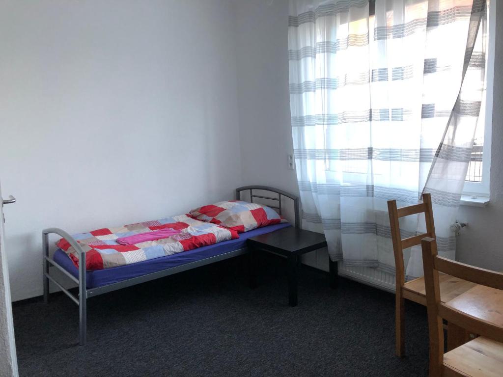 niewielka sypialnia z łóżkiem i oknem w obiekcie Rana's Zimmervermittlung w Bremie