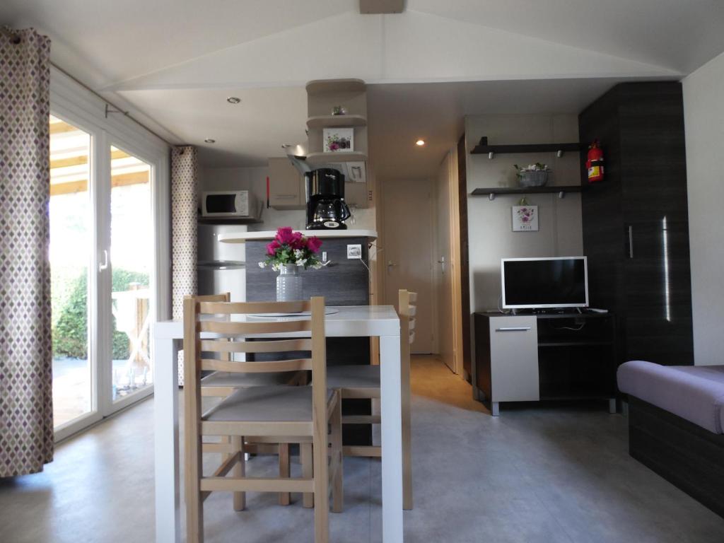 a kitchen and dining room with a table and chairs at Camping les charmettes- in Les Mathes