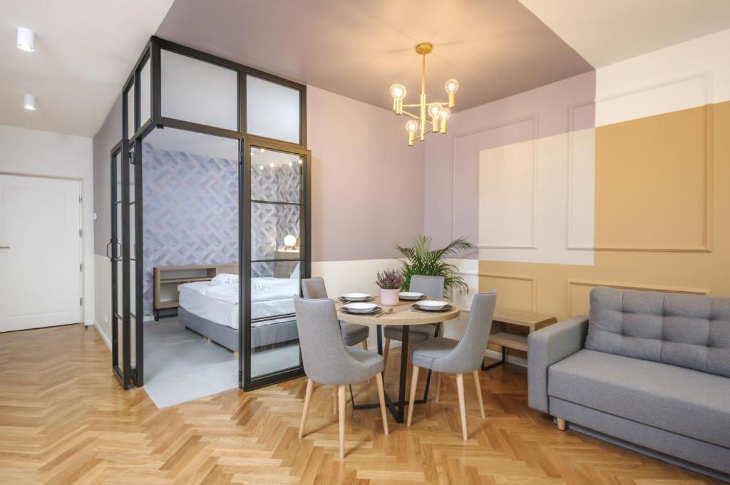 - une salle à manger avec un lit, une table et des chaises dans l'établissement Ermine Suites, à Cracovie