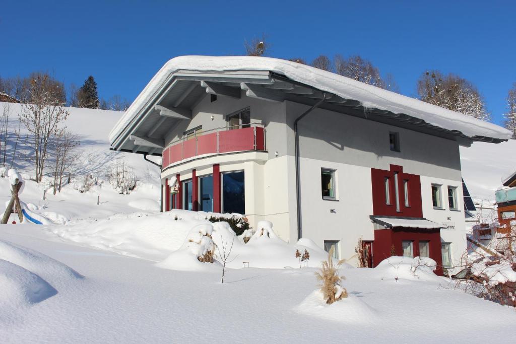 a house with red doors in the snow at Haus Lorenz in Schladming