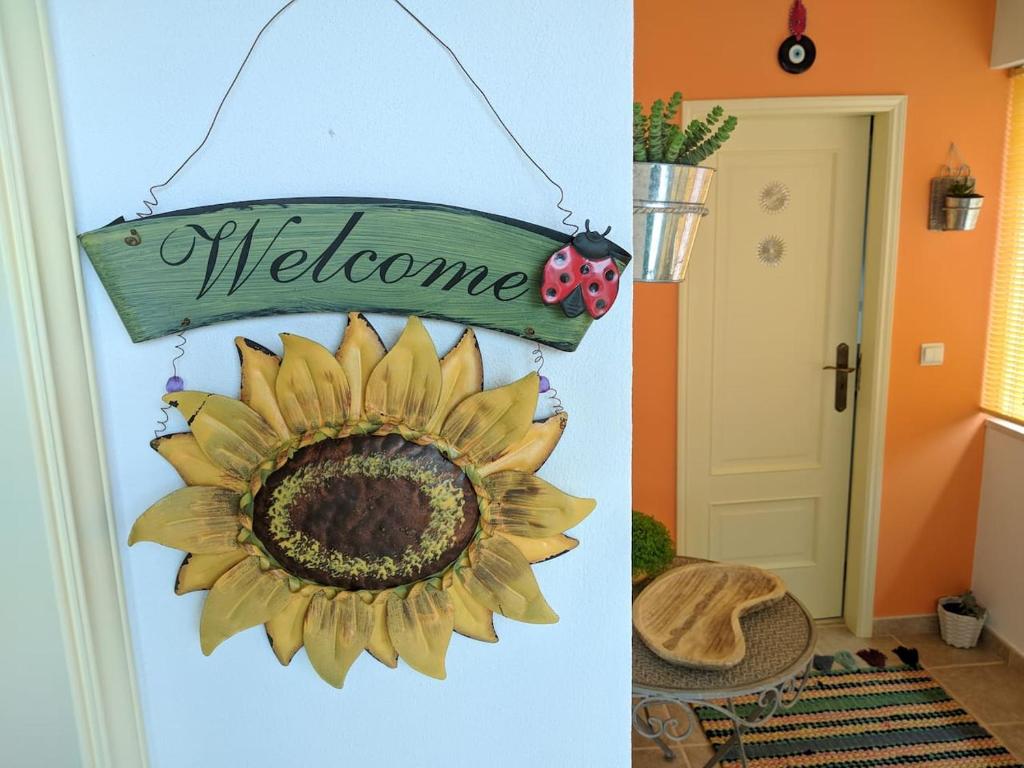 ein Willkommensschild und eine Sonnenblume an der Wand in der Unterkunft Casa Aurora in Penacova