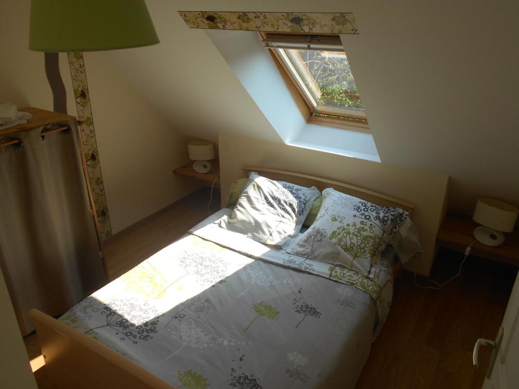 een slaapkamer met een bed en een raam op zolder bij Gîte de la Cuve in Huisnes-sur-Mer