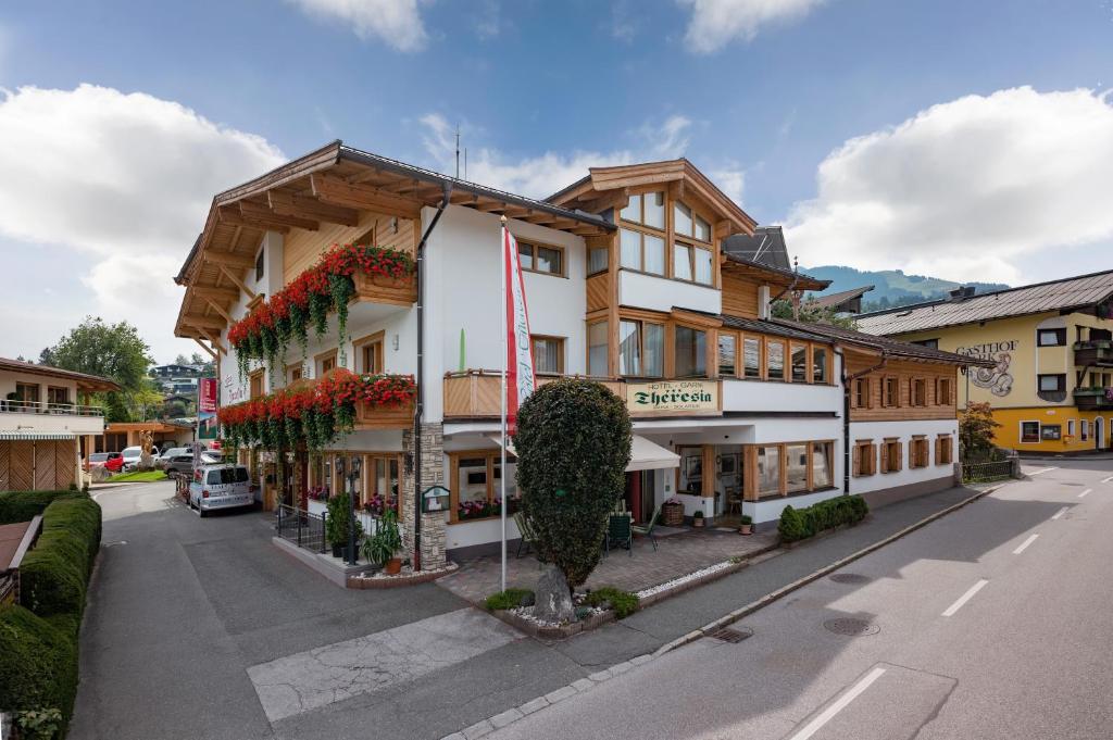 a building with flowers on the side of a street at Hotel Theresia Garni in Sankt Johann in Tirol