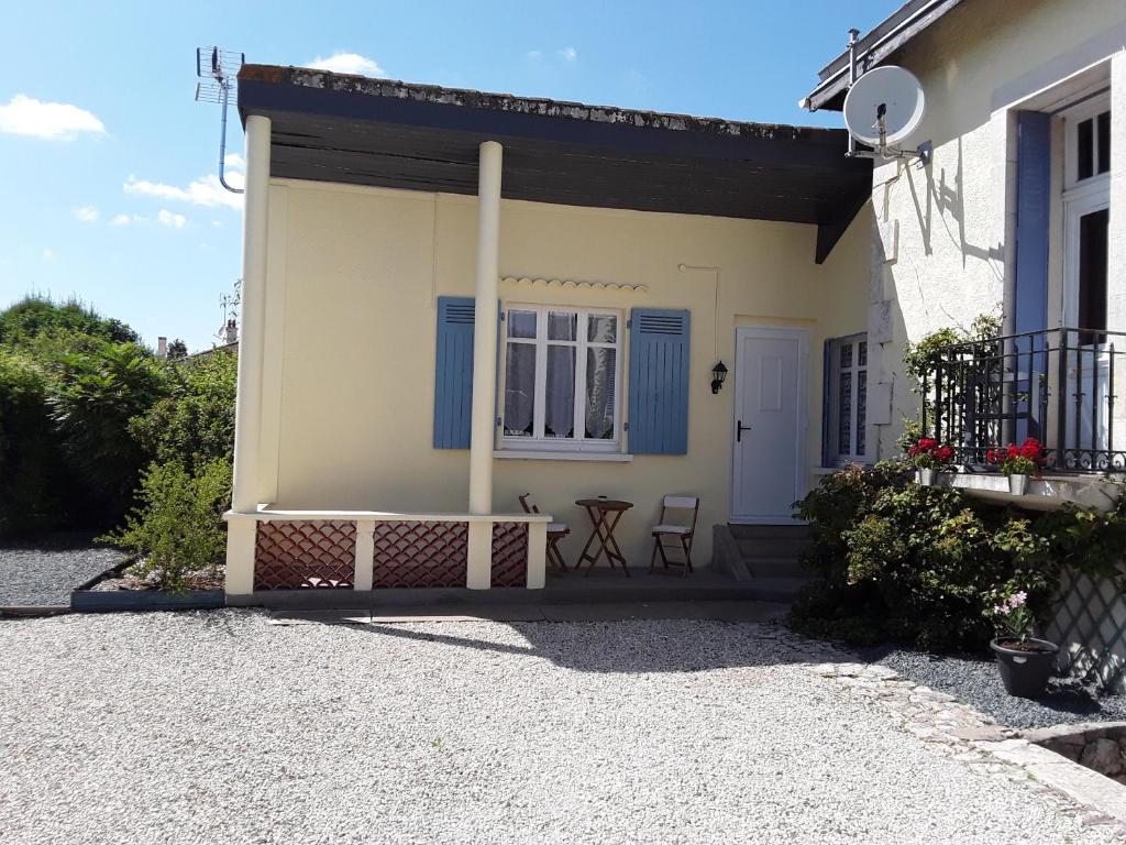 a house with a porch with a table and chairs at Maison Vuyk in Nalliers